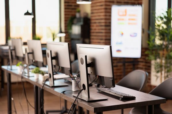 PCs and computer hardware arranged on desks in an office.